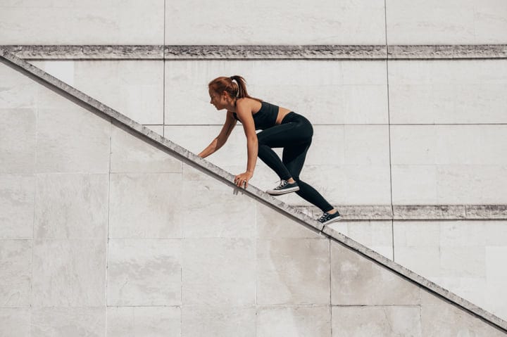 Fearless Woman Scaling Urban Wall With Precision