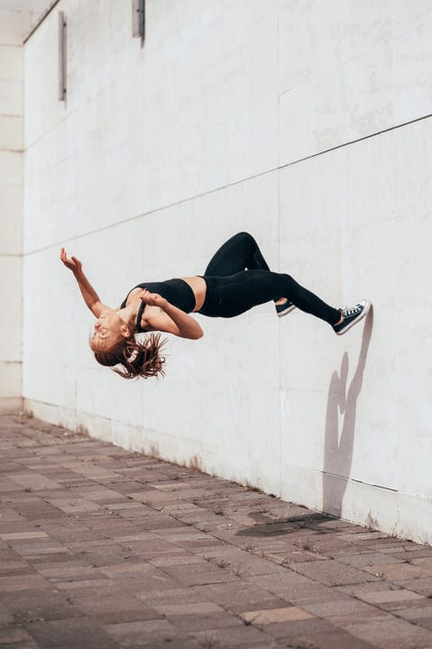 Graceful Flight: Woman Executing Parkour Flip Mid-Air