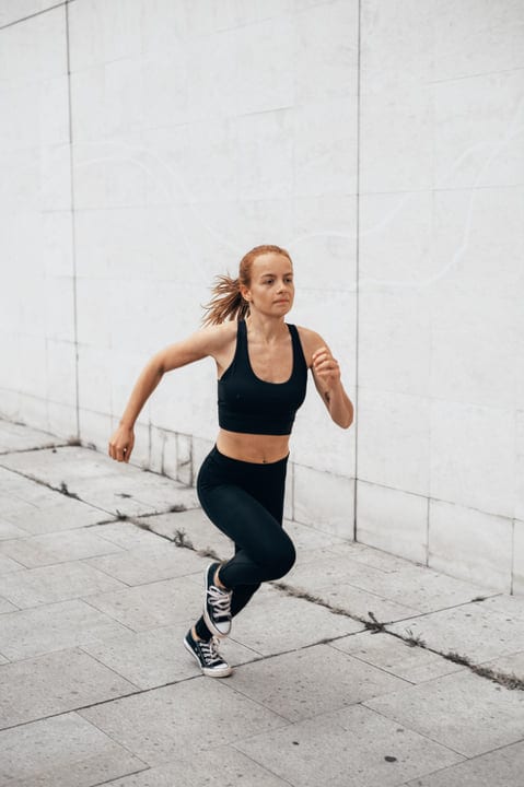 Dynamic Leap Of A Woman In Urban Parkour Setting