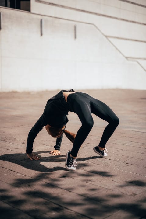 Dynamic Movement: Woman Performing Parkour Backbend Outdoors