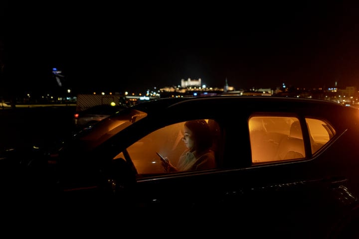 Late Night Drive With Businesswoman Illuminated By City Lights