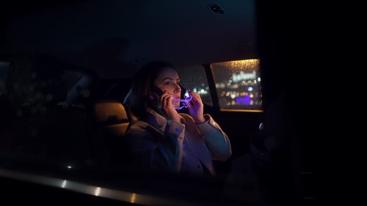A Businesswoman Navigates City Lights On Night Drive