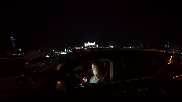 Illuminated Focus: Businesswoman Navigates Night Drive