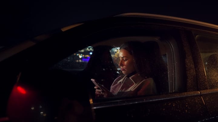 Focused Businesswoman Navigates Cityscape During Night Drive