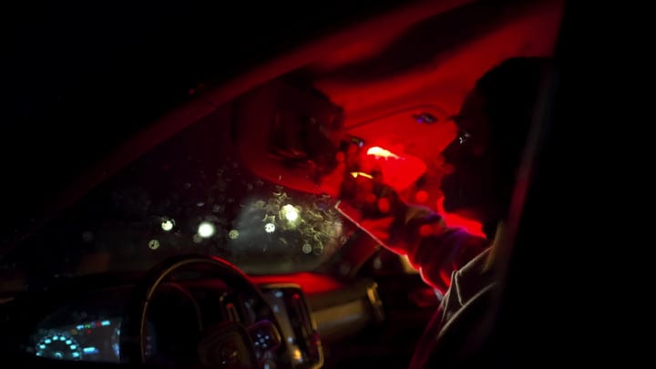 Nighttime Drive Illuminated By City Lights And Red Glow