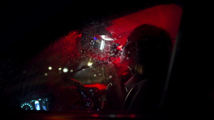 A Businesswoman Navigates A Rainy Night Drive Home