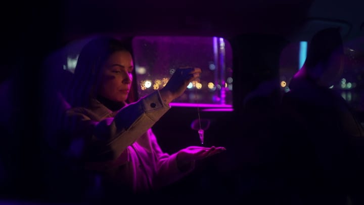 Businesswoman Gazes at City Lights During Night Drive