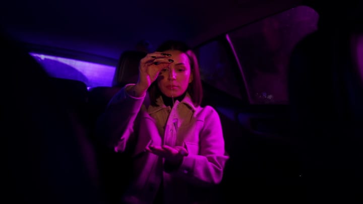 Businesswoman Reflects with Pendant Under Neon Glow