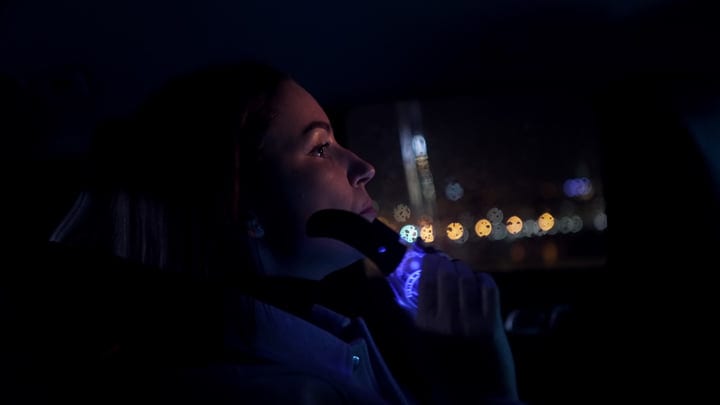 Contemplative Businesswoman Navigates City Lights At Night
