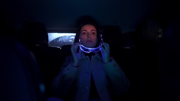 Innovative Businesswoman Embraces Tech on a Rainy Night Drive