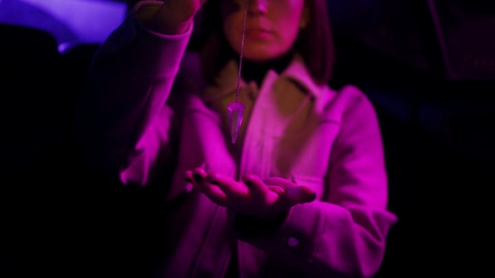 Businesswoman Gazes Intently at Glowing Pendant in Car