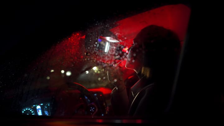 Contemplative Drive Through A Rain-Soaked Night Cityscape