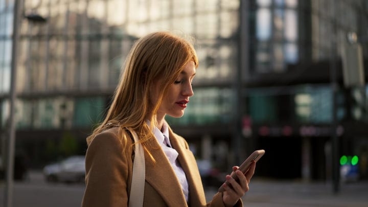 Modern Businesswoman Checks Her Phone In Vienna's Morning Light