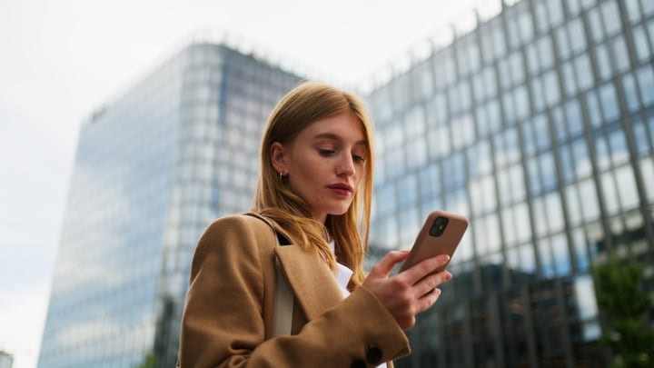 Focused Businesswoman Navigates Her Smartphone In Vienna