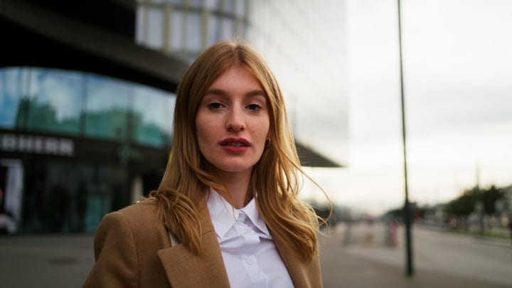 Young Businesswoman Standing Outside Modern Office Building In European City