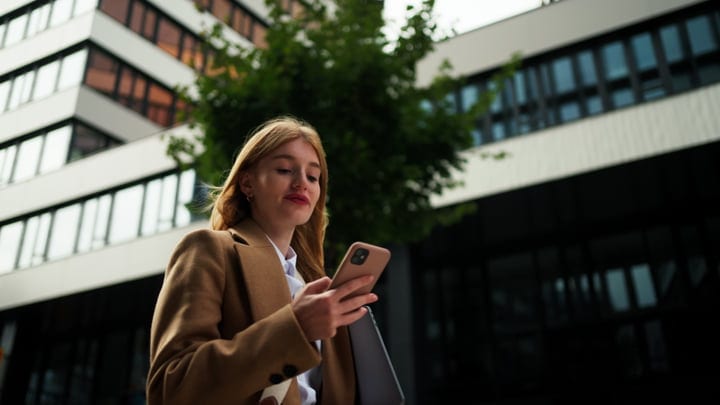 Businesswoman Checks Her Phone In Urban Vienna Setting