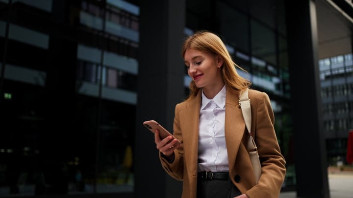 Confident Businesswoman Checks Her Phone In The City