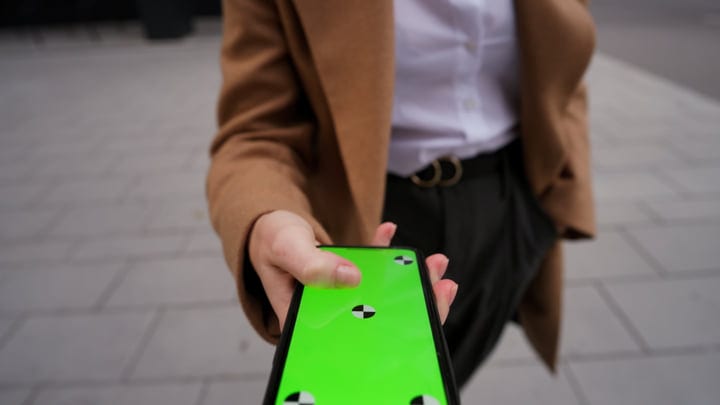 A Businesswoman Extends Her Smartphone During A Break