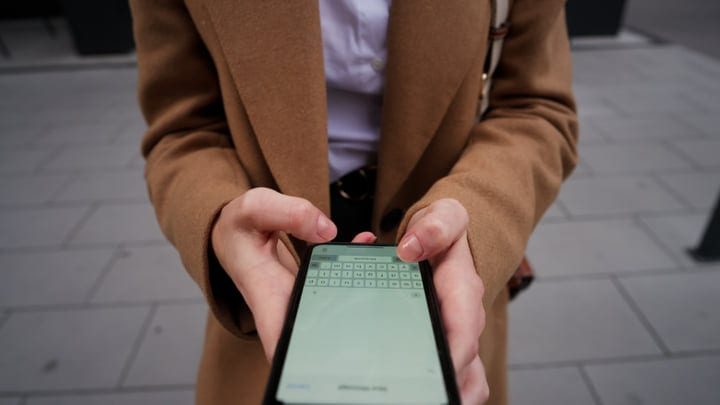 Businesswoman Engages With Her Smartphone On Vienna Street