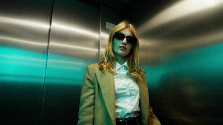 Confident Businesswoman in Elevator with Sunglasses and Style