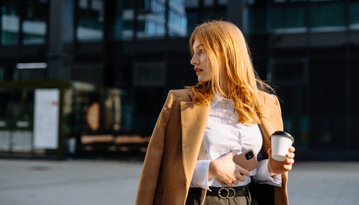 Businesswoman Embraces Autumn Sunlight With Coffee In Hand