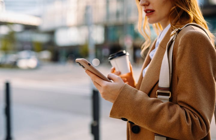 Businesswoman Engages With Smartphone On A Vibrant Vienna Street