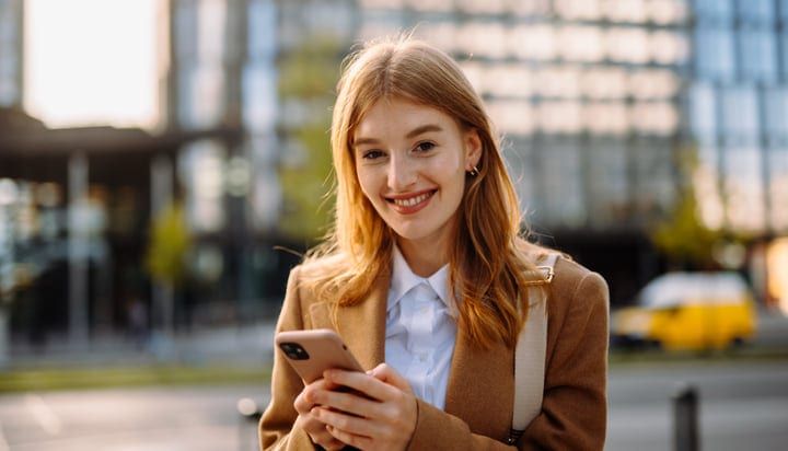 Confident Businesswoman Engages With Her Smartphone Outdoors