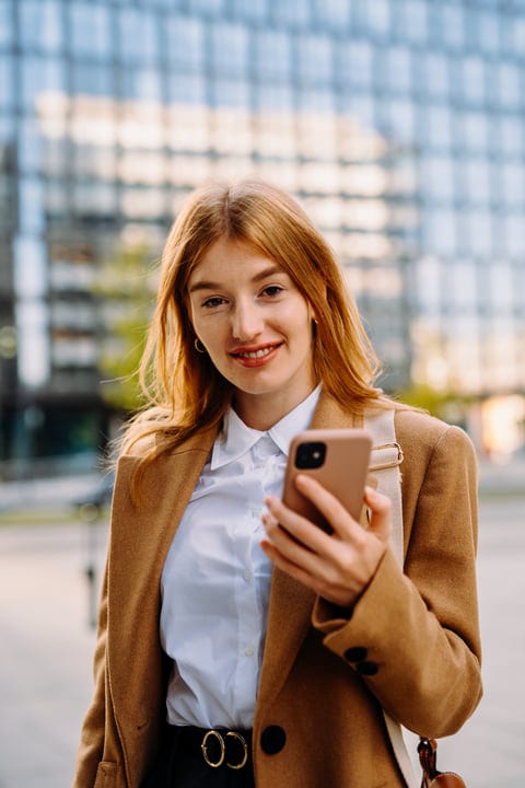 Confident Businesswoman Engages With Smartphone In Vienna Street