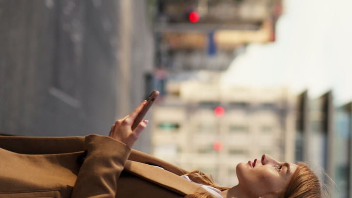 Businesswoman Gazes Upward With Phone In Hand On Vienna Street