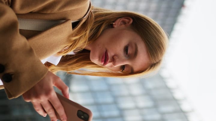 Young Professional Engages With Smartphone In Vienna Cafe