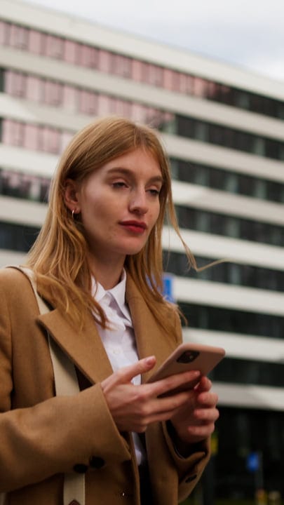 Businesswoman Engages with Smartphone Outside Vienna Cafe