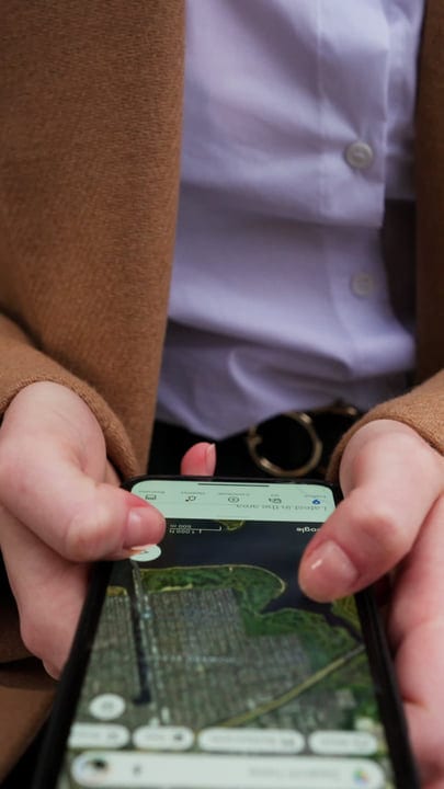 Businesswoman Navigates Urban Map On Her Smartphone