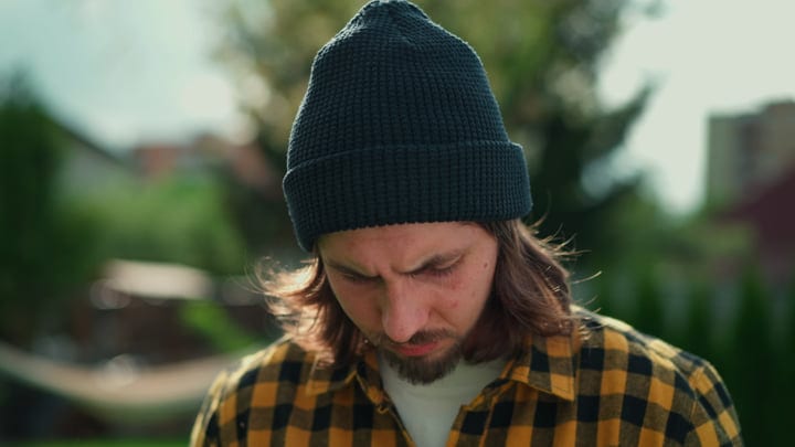 Focused Gardener Contemplates Lawn Care Under Autumn Sun
