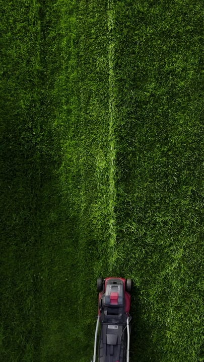 Aerial View Of Gardener Mowing A Perfectly Green Lawn