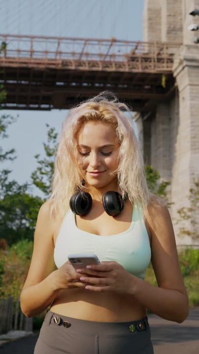 Young Woman Enjoying Music On Her Phone Outdoors