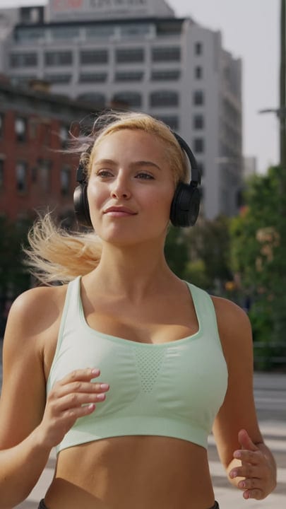 Urban Runner in Headphones Enjoying a Sunny Morning