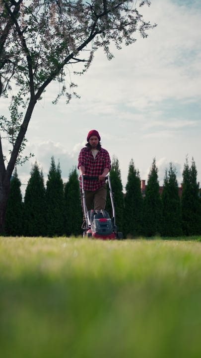 Gardener Enjoys A Serene Afternoon Lawn Mowing