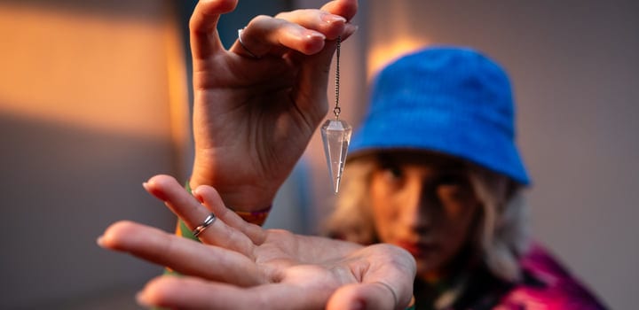 Gen Z Hand Holds a Crystal Pendant with Focus