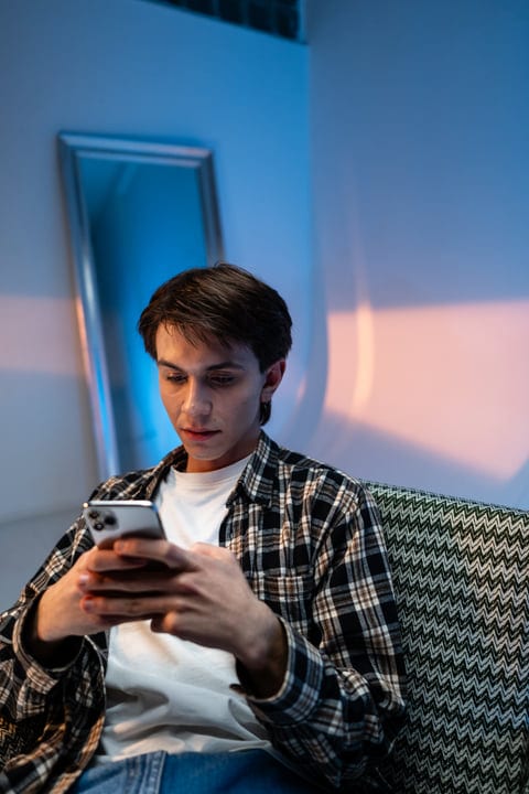 Gen Z Focused on Smartphone in Cozy Studio Setting