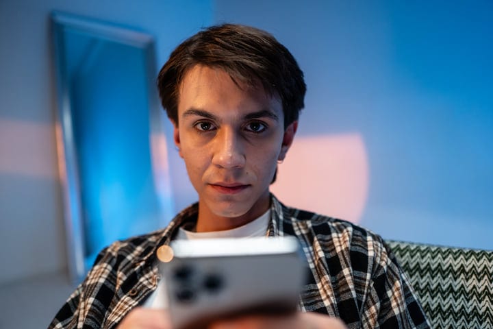 Young Man Engaged With Smartphone In Contemporary Studio Setting