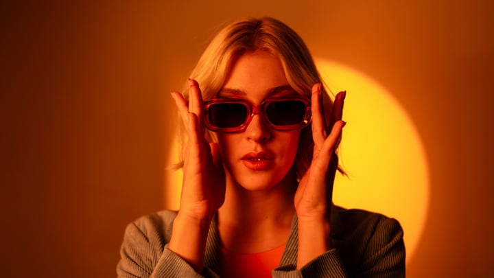 Gen Z Woman Embraces Bold Sunglasses Style in Studio