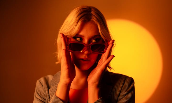 Gen Z Portrait In Warm Studio Glow With Sunglasses
