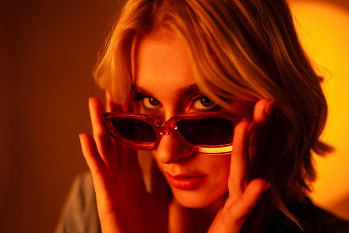Playful Glances Through Bold Sunglasses In Warm Light