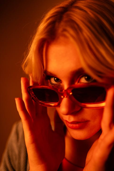 Gen Z Glance Through Vibrant Sunglasses In Studio Light