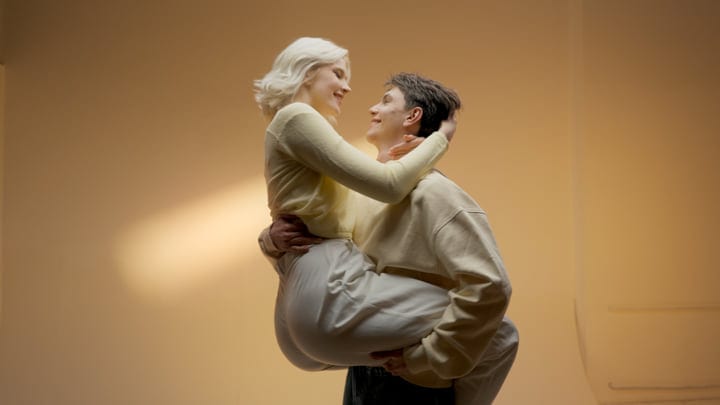 Young Couple Embracing in Warm Studio Light