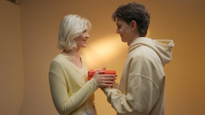 Young Pair Exchanges Gifts in Warm Studio Light