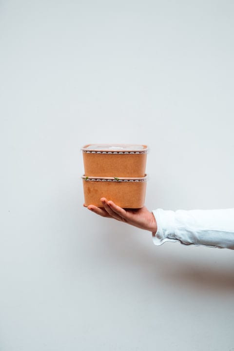 Hand Holding Stack Of Eco-Friendly Food Containers