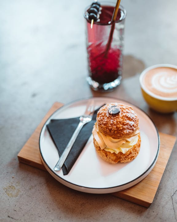 Indulgent Cream Puff Paired With Latte And Berry Drink