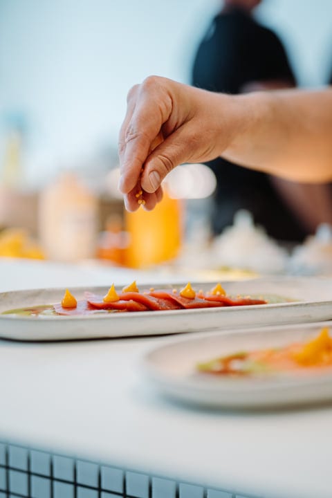 Chef's Hand Perfectly Seasons A Vibrant Gourmet Dish