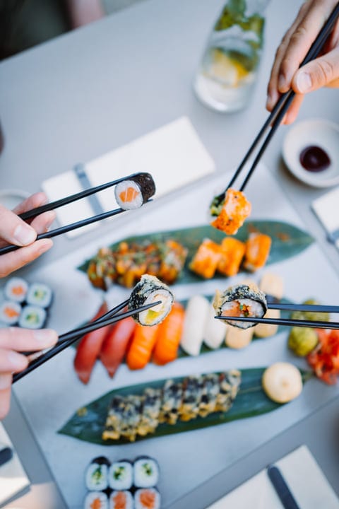 Chopsticks Dance Over A Platter Of Fresh Sushi
